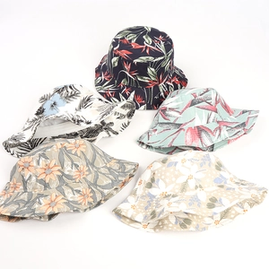 Flat lay of five cotton bucket hats featuring diverse tropical leaf and floral prints