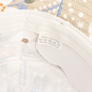 Detail of printed cotton sun hat interior showing stitching and 100% cotton label