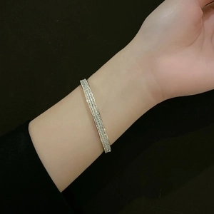Detailed view of silver titanium steel bangle with full pavé cubic zirconia on wrist