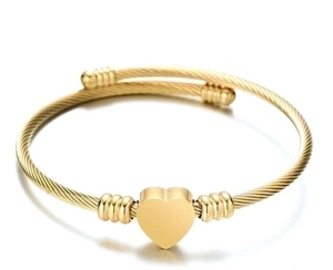 Close-up of golden cable wire texture and heart charm on stainless steel open bangle