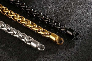 Gros plan sur des bracelets de chaîne de quille en acier titane argenté, doré et noir tressé