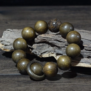 Détail macro de perles en bois Phoebe Zhennan de 20mm avec fine gravure de fortune
