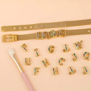 Close-up of gold mesh bracelet with colorful rhinestone alphabet slider charms