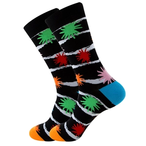Close-up of crew socks featuring colorful sunflower patterns and orange toe detail