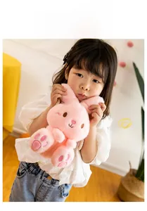 Detailed close-up of a pink plush bunny bag for kids with long ears and woven strap