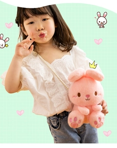 Toddler girl holding a cute pink plush bunny toy with long ears and soft fabric
