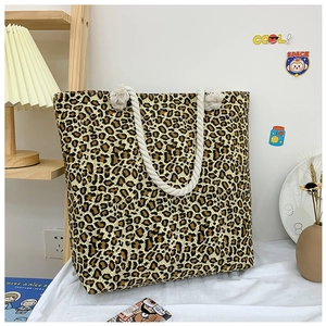 Detail of leopard print canvas tote bag with thick beige rope handles in a lifestyle setting