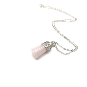Detail of rose quartz point pendant featuring an intricate silver floral metal cap