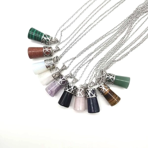 Close-up of ten assorted natural stone crystal point necklaces with silver floral caps
