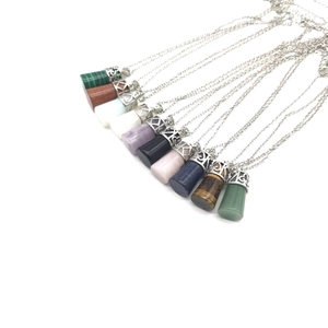 Macro shot of assorted natural crystal hexagonal pendants with ornate silver metal caps