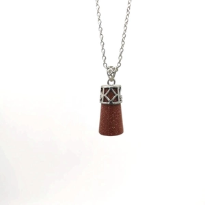 Detailed view of vintage sword pattern metal cap on brown goldstone pendulum necklace