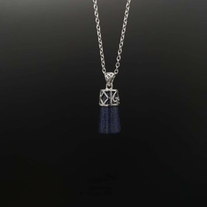 Macro detail of natural lapis lazuli pendant with ornate silver metal filigree and chain
