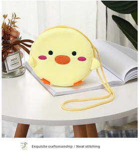 Detail of yellow plush cartoon duck crossbody bag with embroidery and soft texture