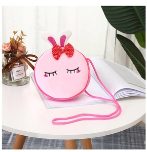 Close-up of pink plush unicorn crossbody bag with bunny ears and a red polka dot bow
