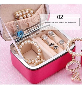 Pink leather jewelry box interior with necklace hooks and velvet ring storage slots