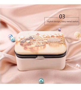 Detail of portable jewelry box with metal snap button and printed pattern on pink silk