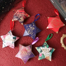 Star-shaped gift boxes with decorative ribbons in various colors on red fabric background