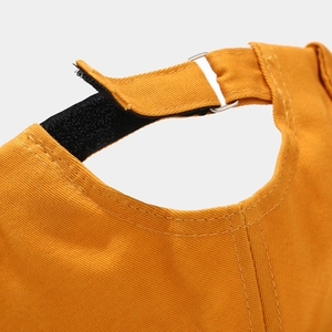 Detail view of ginger yellow brimless cap with adjustable velcro strap and metal buckle