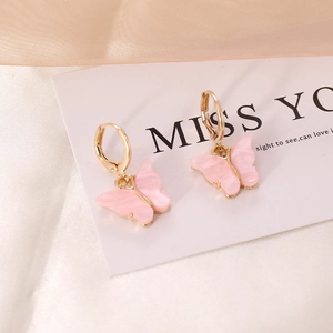 Chic pink resin butterfly drop earrings with golden frames on a silk background