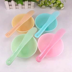 Set of four colorful plastic DIY facial mask mixing bowls with spatulas in macro view