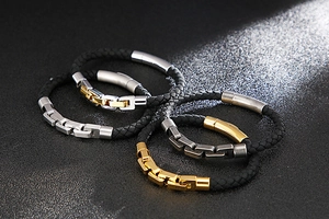 Detail of woven leather bracelets for men featuring gold, silver, and gunmetal clasps