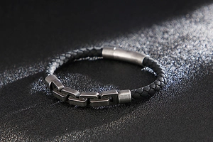 Macro shot of men's braided leather bracelet featuring vintage silver metal link accents