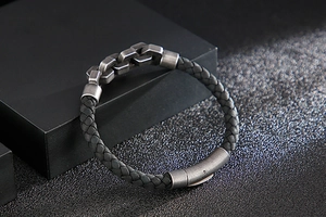 Close-up of woven black leather texture and vintage silver chain link buckle on bracelet
