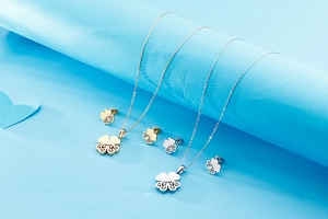 Detail of hollow four-leaf clover necklace and earrings set in gold and silver finish