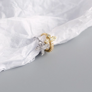Detailed close-up of gold and silver S925 cross earrings with sparkling zircon stones