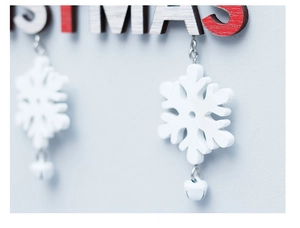 Close-up of wooden Christmas pendant with snowflake detail and holiday engraving