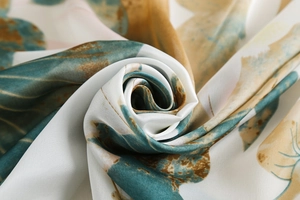 Macro shot of silk satin fabric showing elegant botanical leaf patterns and shiny texture
