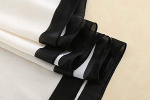Detail of soft silk scarf featuring black and white stripe pattern and smooth texture