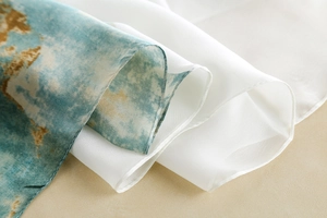 Detailed view of the fine rolled edge and blue-white gradient print on silk scarf