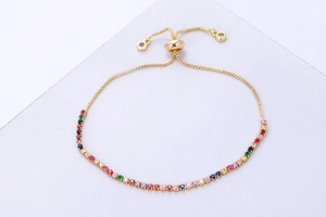 Close-up of rainbow cubic zirconia tennis bracelet with adjustable golden slide buckle