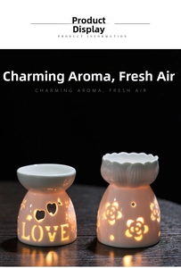 Detail of white ceramic oil burners with LOVE heart and floral cutouts on black background