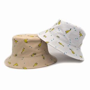 Detailed close-up of cotton bucket hats featuring cartoon duck prints and blue polka dots