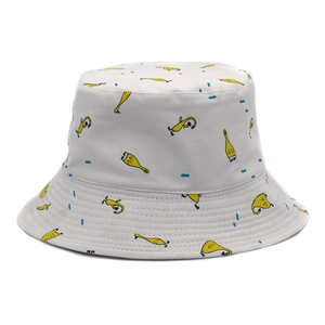 Detailed close-up of a white cotton bucket hat with yellow cartoon prints and blue dots