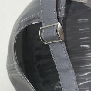 Detailansicht der grauen Kappe mit verstellbarem Riemen und silberner Metallschnalle hinten