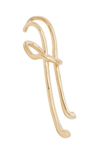 Close-up of golden irregular geometric ear cuff with polished flowing metallic lines