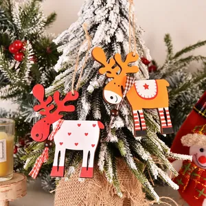 Colorful wooden reindeer Christmas tree ornaments with hanging ropes on snowy branches