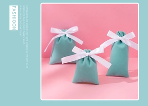 Close-up of Tiffany blue velvet jewelry pouches with white silk ribbon bow ties