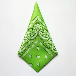 Close-up of green paisley bandana with white floral pattern on a flat polyester fabric