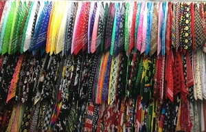 Rack display showing multiple paisley and graphic print bandanas in various colors