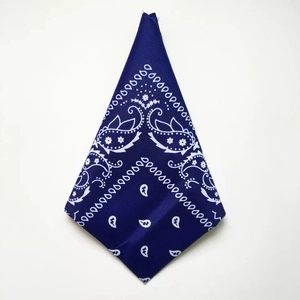 Detail of blue paisley pattern square bandana with white floral print on polyester fabric