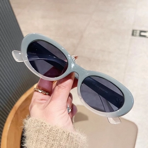 Detail view of oval sunglasses showing internal frame dimensions and grey UV lenses