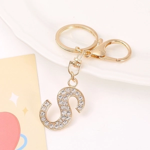 Macro detail of gold letter S keychain with rhinestones and lobster clasp hardware