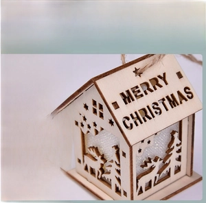Detail of wooden Christmas house featuring Merry Christmas engraving and LED lighting