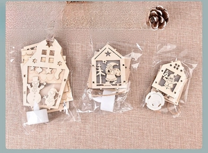Detail of wooden Christmas LED house ornaments with OPP bag packaging and snowman motifs