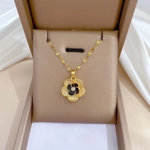 Elegant gold titanium steel flower necklace with black and white petals in a jewelry box