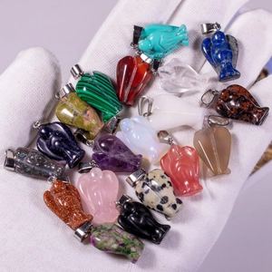 Various natural stone angel pendants in rose quartz and amethyst held in hand